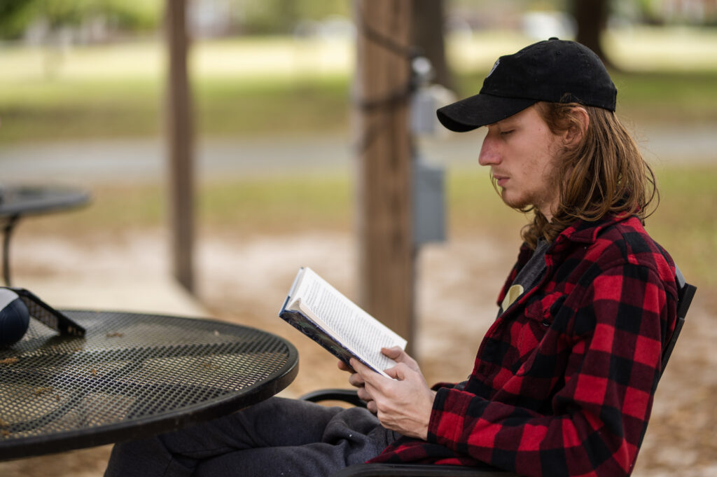student reading a book outside