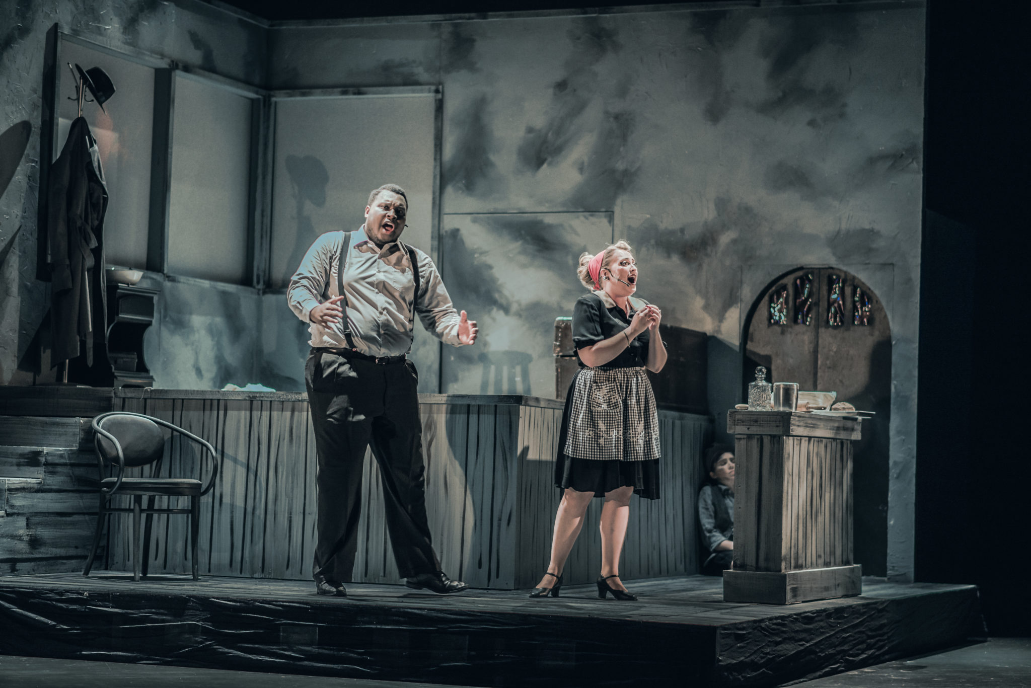 Two students singing on stage during a performance of Sweeney Todd