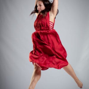 Jennifer Bailey mid-jump in a red dress