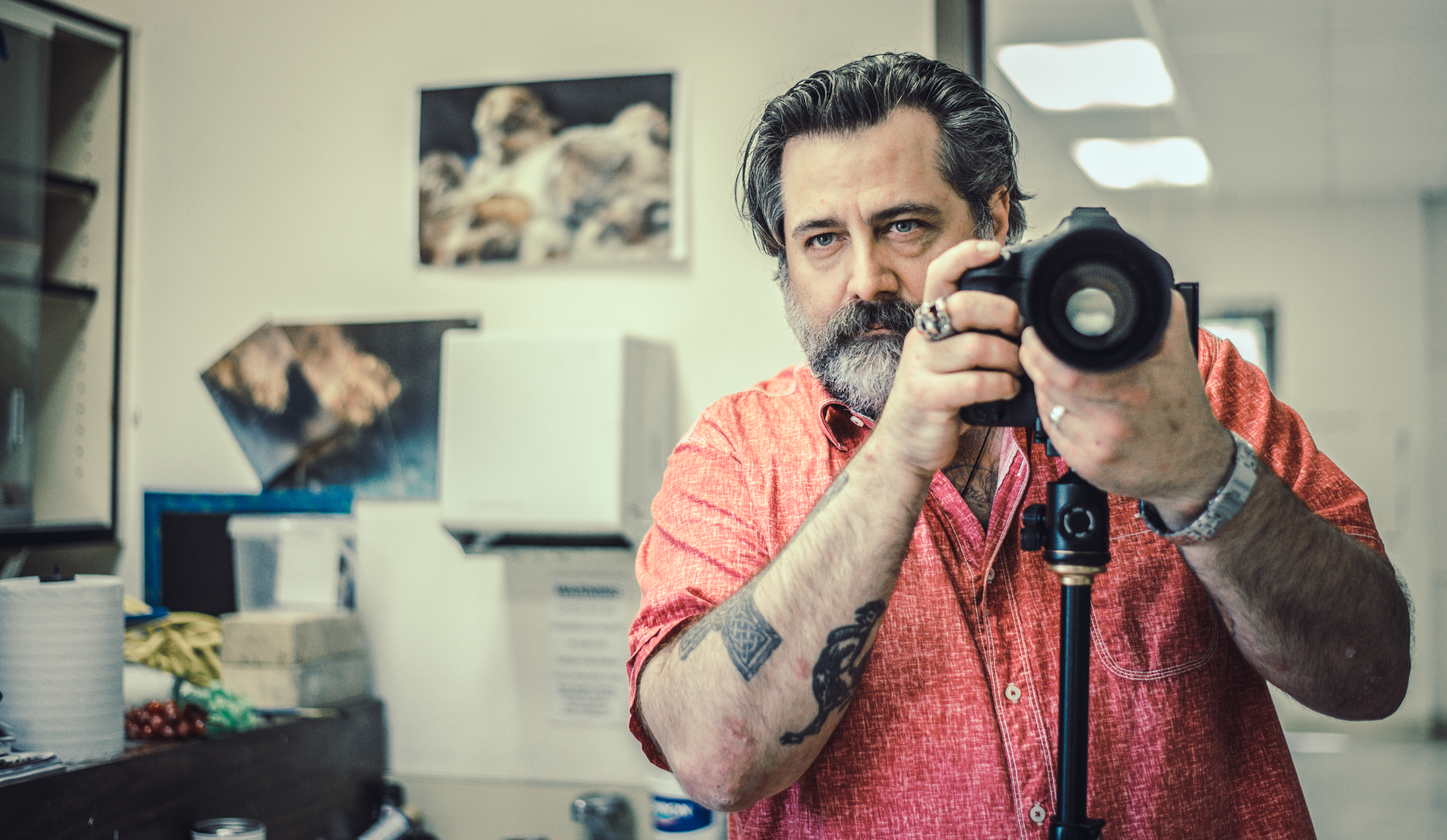 A photography student holds his camera in an art studio