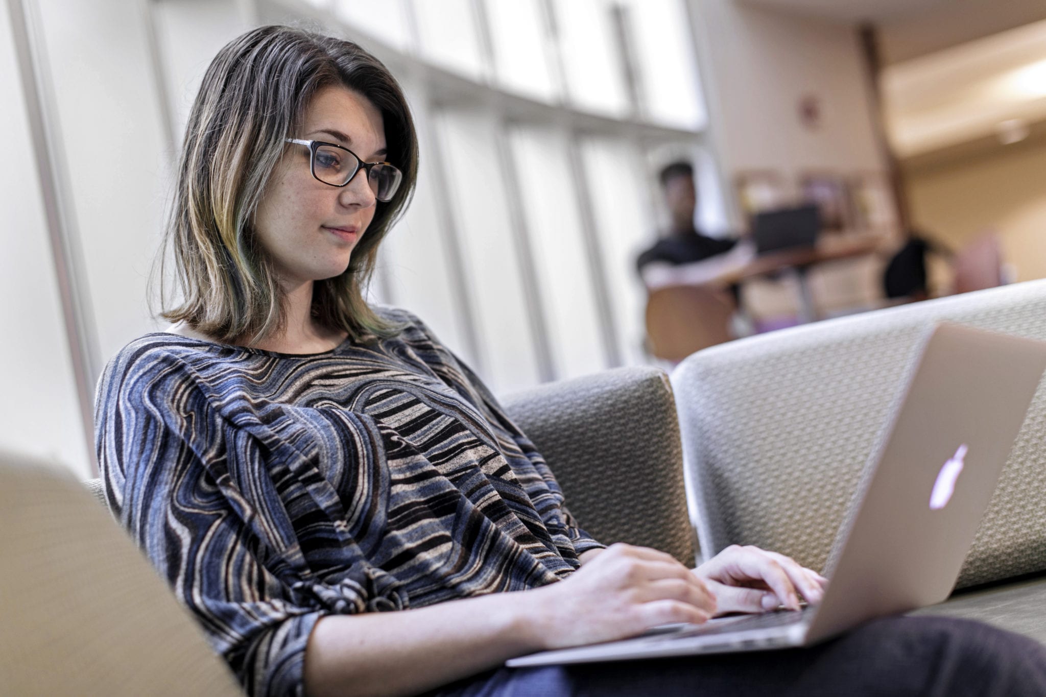 A female student works on a laptop in the Coker library