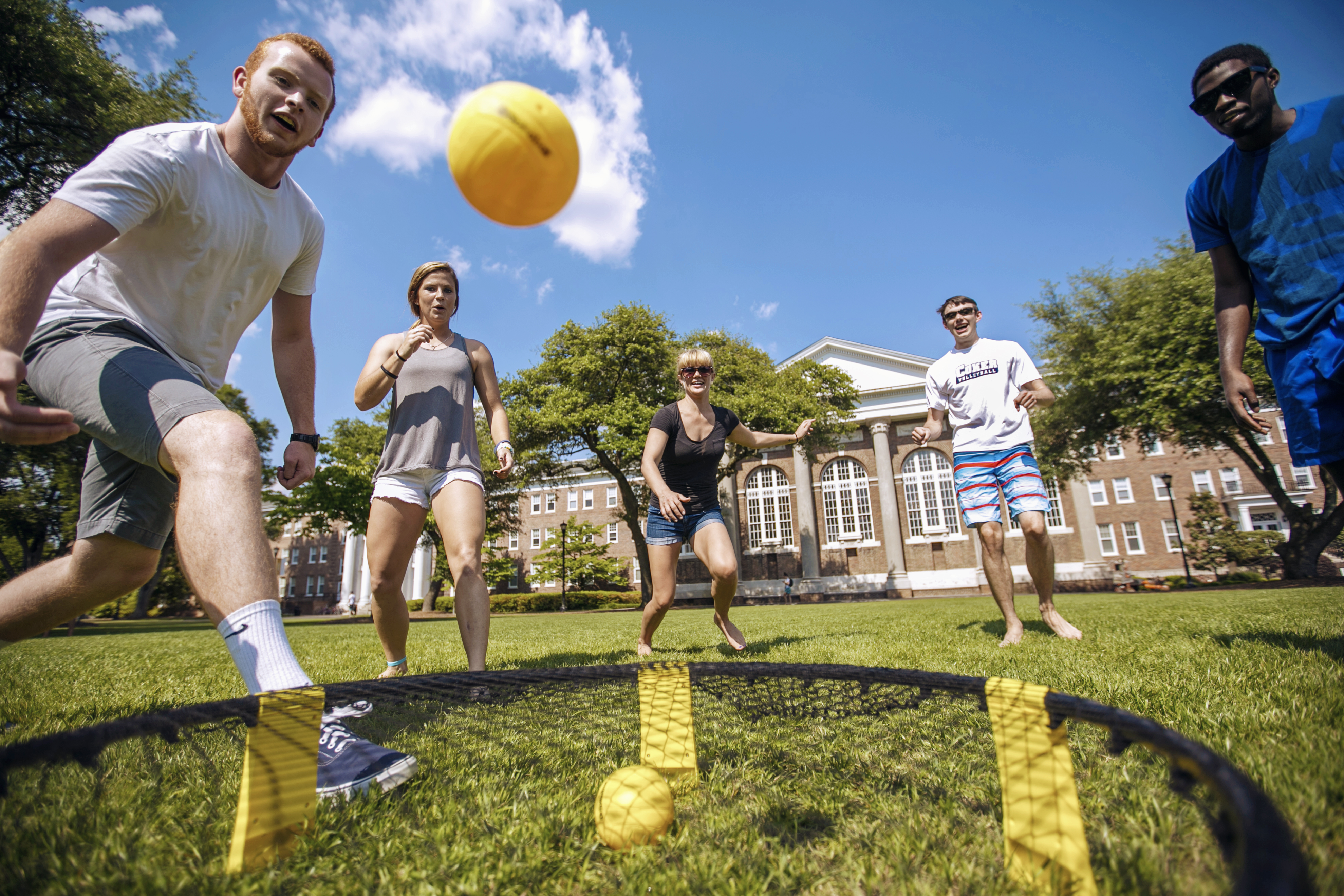 Students kick a ball around on the Davidson Hall lawn on a sunny afternoon