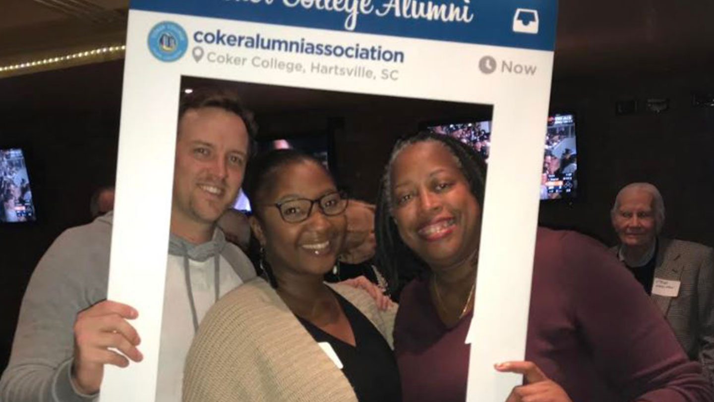 A group of alumni pose at an event.