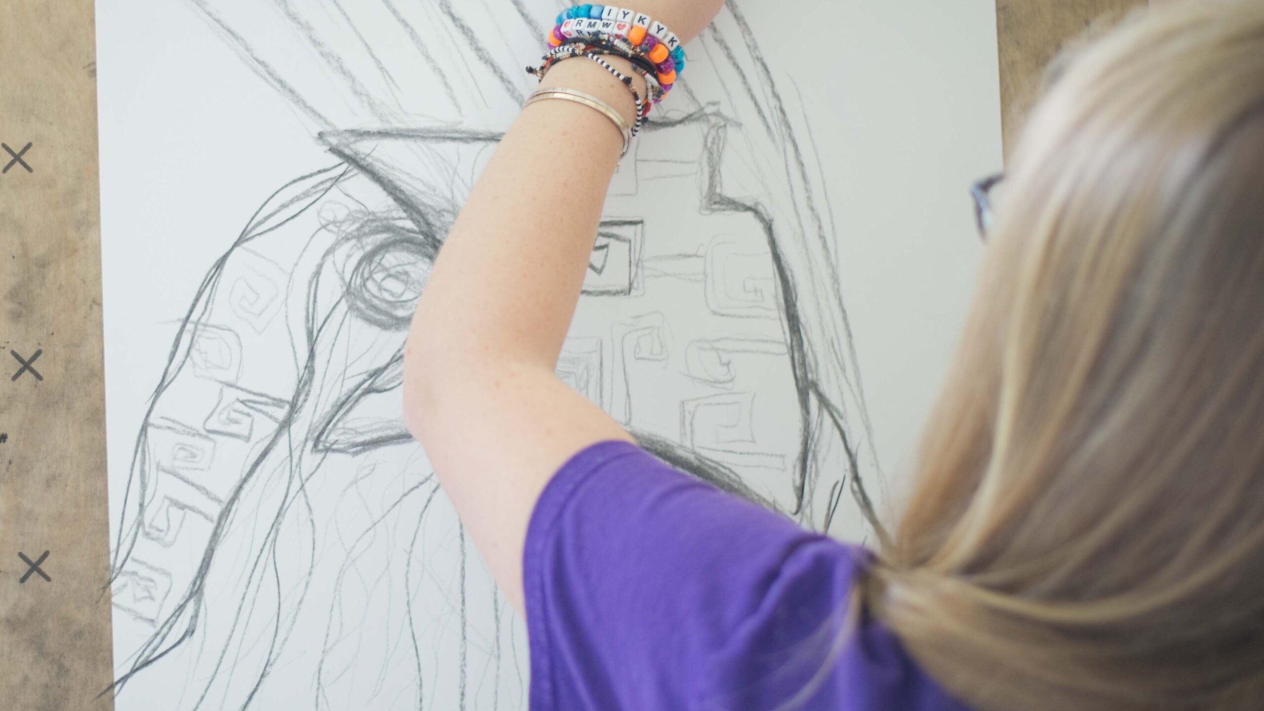 A student sketches on paper taped to an easel