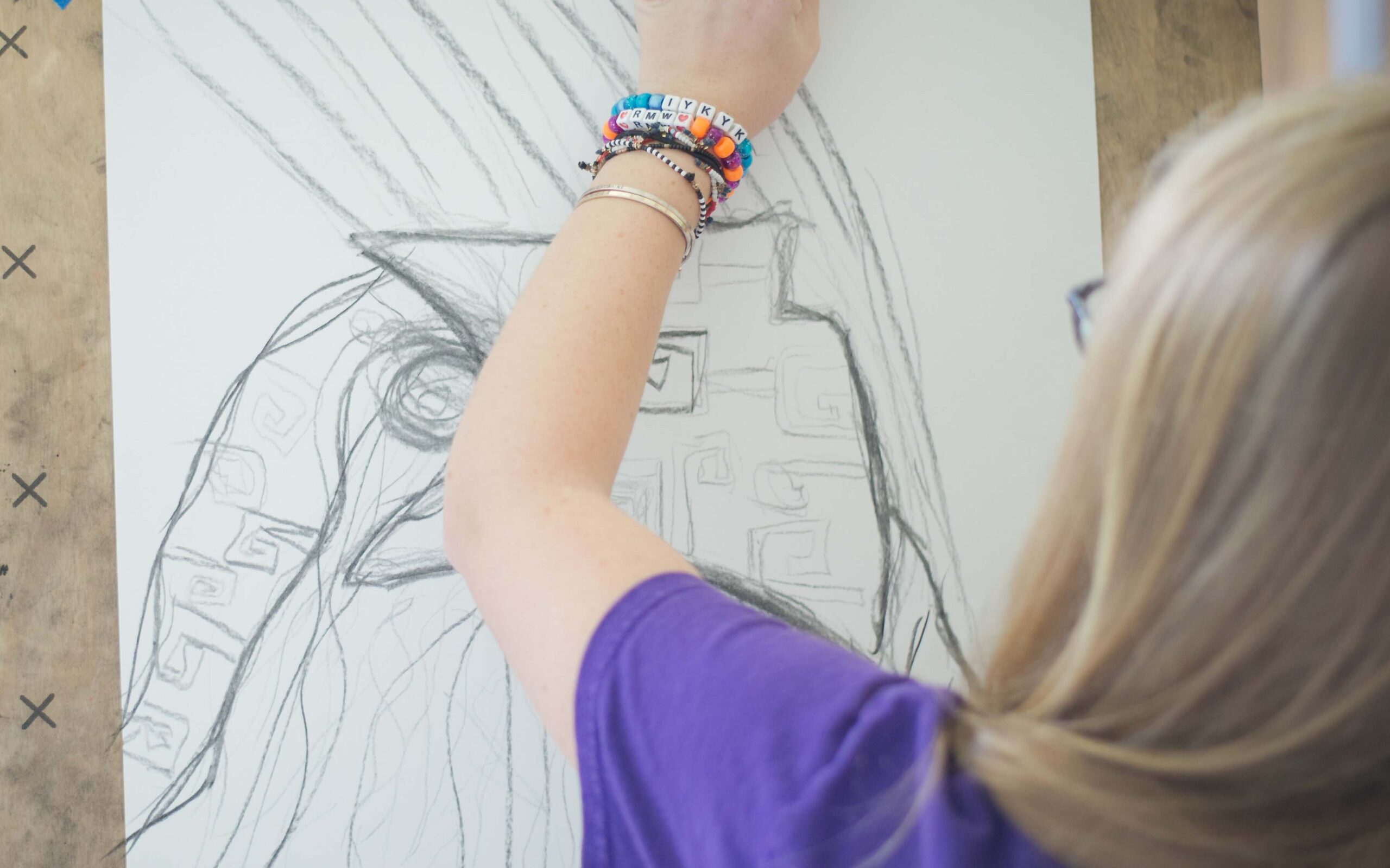 A student sketches on paper taped to an easel