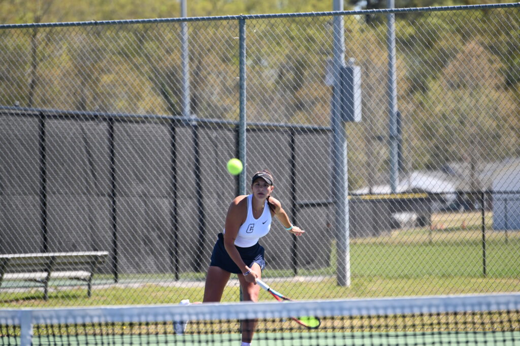 A Coker tennis player serves the ball.