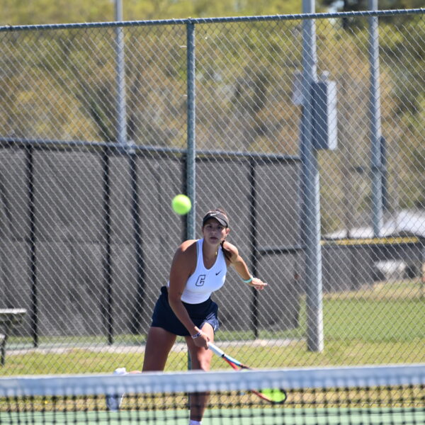 A Coker tennis player serves the ball.