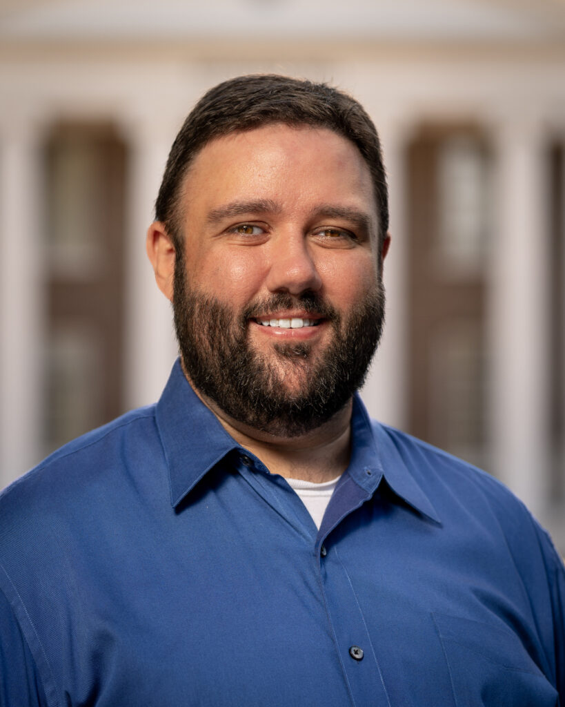 Josh Chandler smiles in front of Davidson Hall for his headshot. 