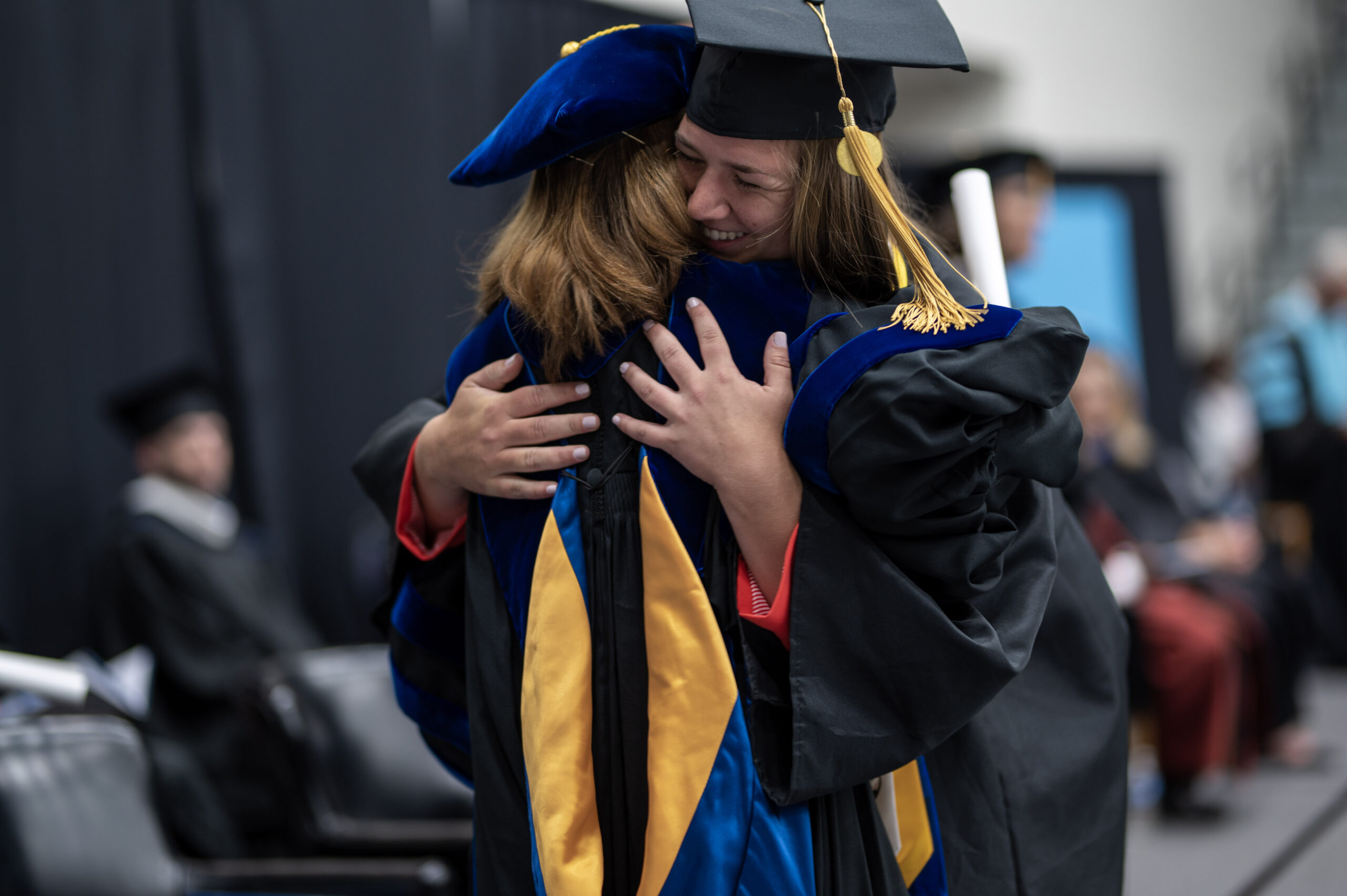 President Dr. Natalie Harder hugs a student at graduation.