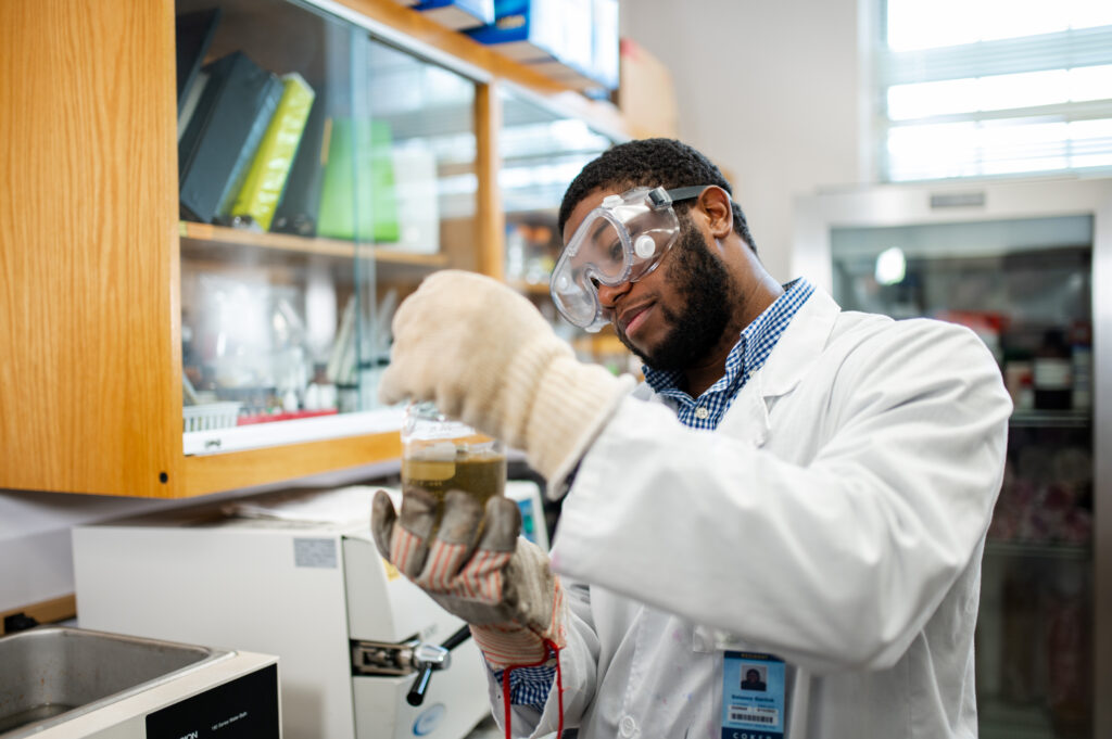 a student looks at a vial